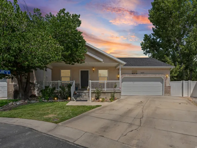 Ranch-style exterior featuring a covered porch with white railing, stone accents, and an attached two-car garage