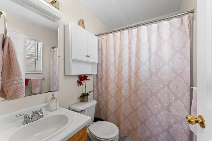 Bathroom featuring a vanity with an integrated sink and chrome faucet, a wall-mounted medicine cabinet, and a toilet