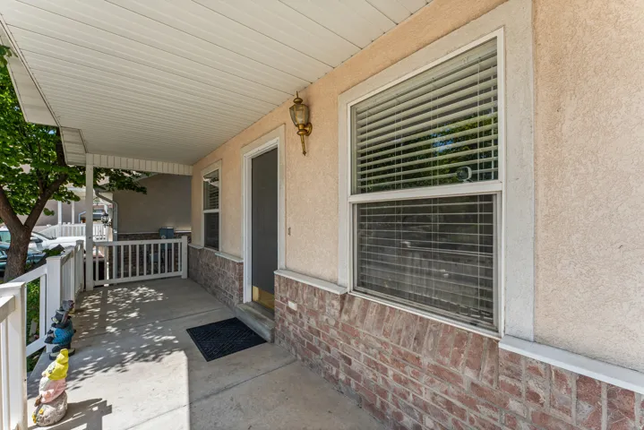Covered porch entry featuring a stucco and brick facade