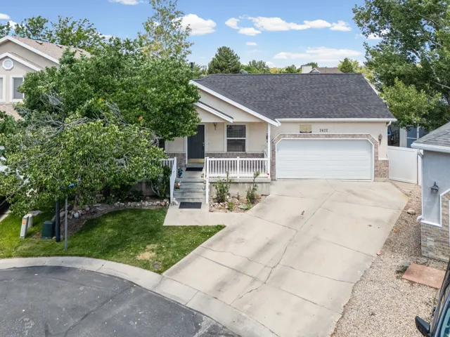 Single-story residence featuring a two-car garage, concrete driveway, and a covered porch with white railing