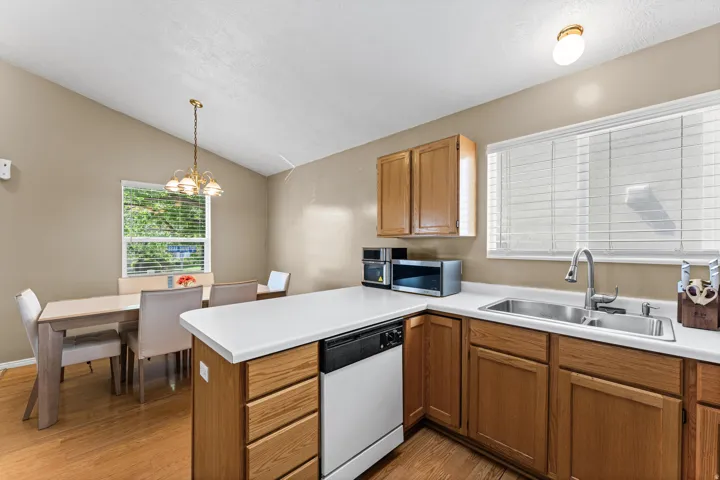 Kitchen with wood-finish flooring, light wood cabinetry, and white countertops