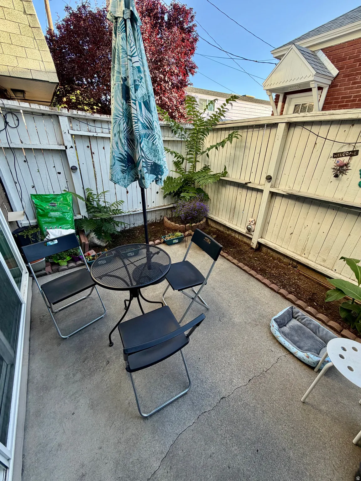 Private concrete patio bordered by a light-colored wooden fence