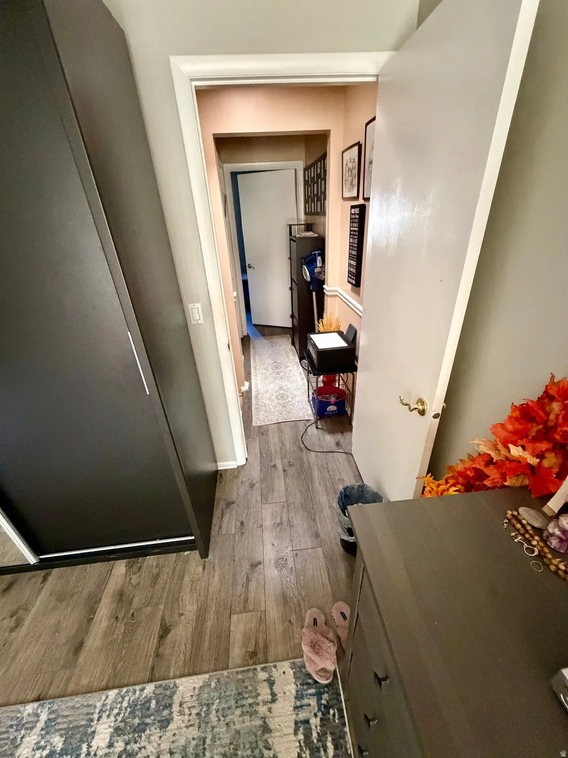 Hallway featuring wood-finish flooring, light-colored walls, and white trim