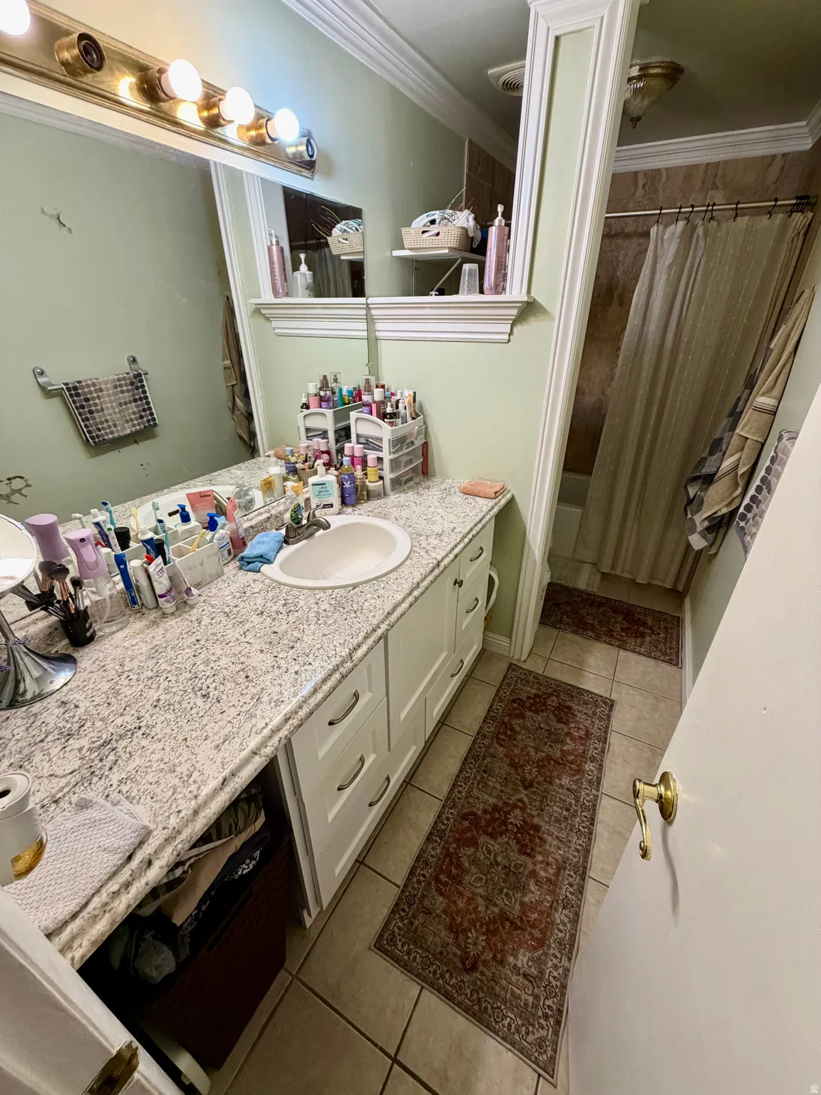 Bathroom featuring a white vanity with an undermount sink, a light-toned countertop, and white cabinetry with drawer pulls