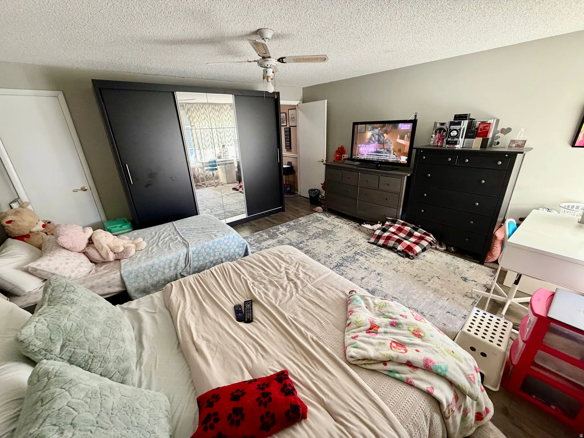 Spacious room featuring wood-finish flooring and light-toned wall paint