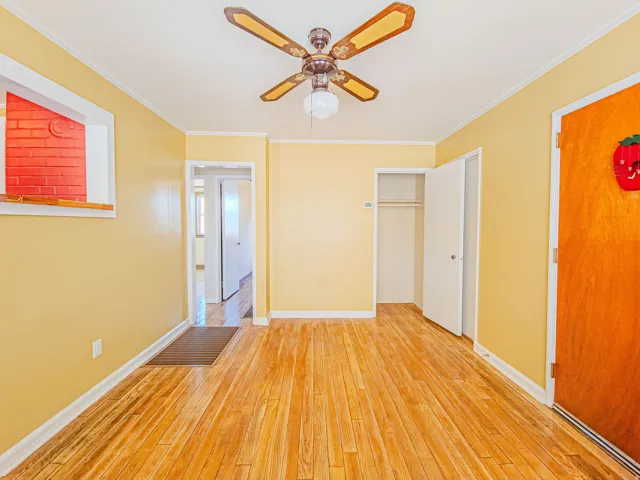 Hardwood flooring extends throughout this room, featuring a ceiling fan with integrated lighting