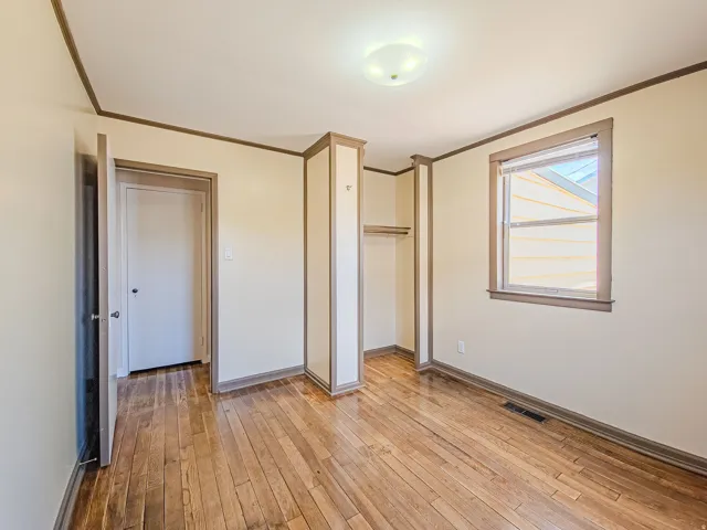 Hardwood flooring throughout featuring an open closet space