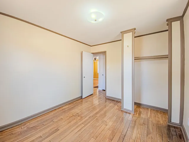 Room featuring wood-finish flooring, neutral wall tones, and contrasting trim