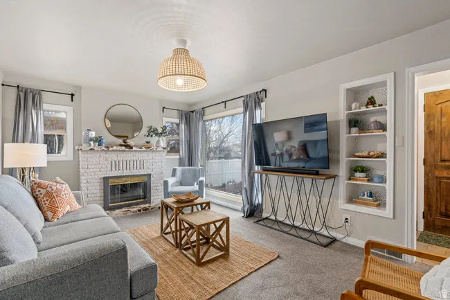 Living area featuring light-colored walls and grey carpet flooring