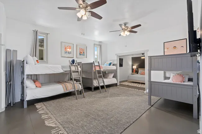 Spacious room featuring light gray flooring, a large area rug, and multiple windows