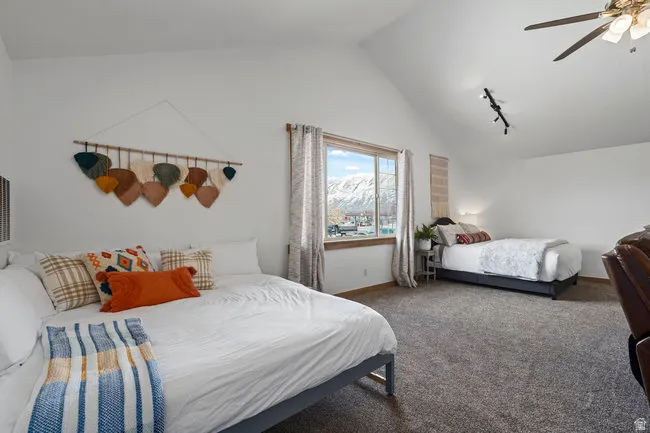 Spacious room with vaulted ceilings and textured carpeting