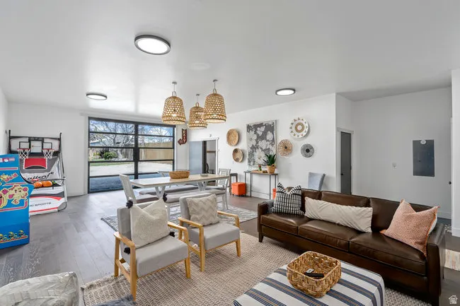 Open-concept living space featuring wood-finish flooring, recessed lighting, and a large glass-paned garage door leading to the exterior