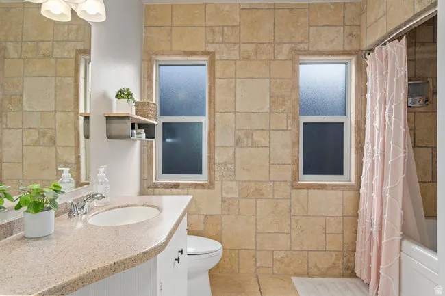 Bathroom featuring natural stone tile walls and flooring
