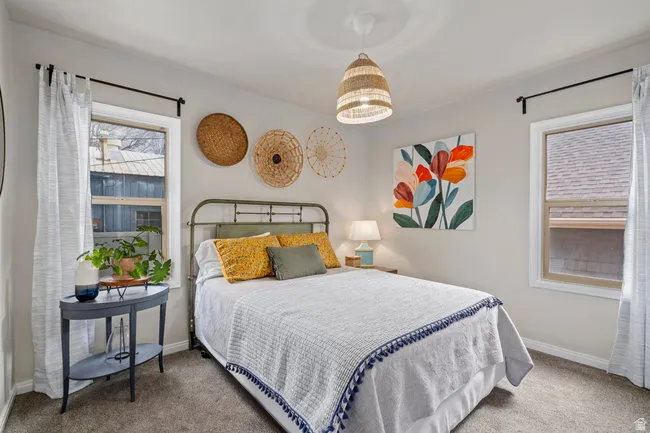 Bright room featuring two windows with white trim and dark curtain rods