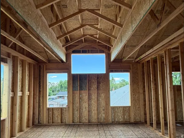 Primary bedroom with vaulted ceilings and large windows.