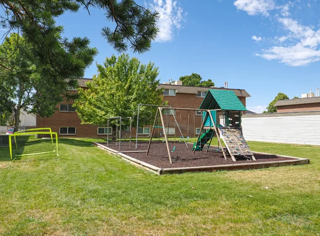 Outdoor play area with shade and rubber mulch for safety