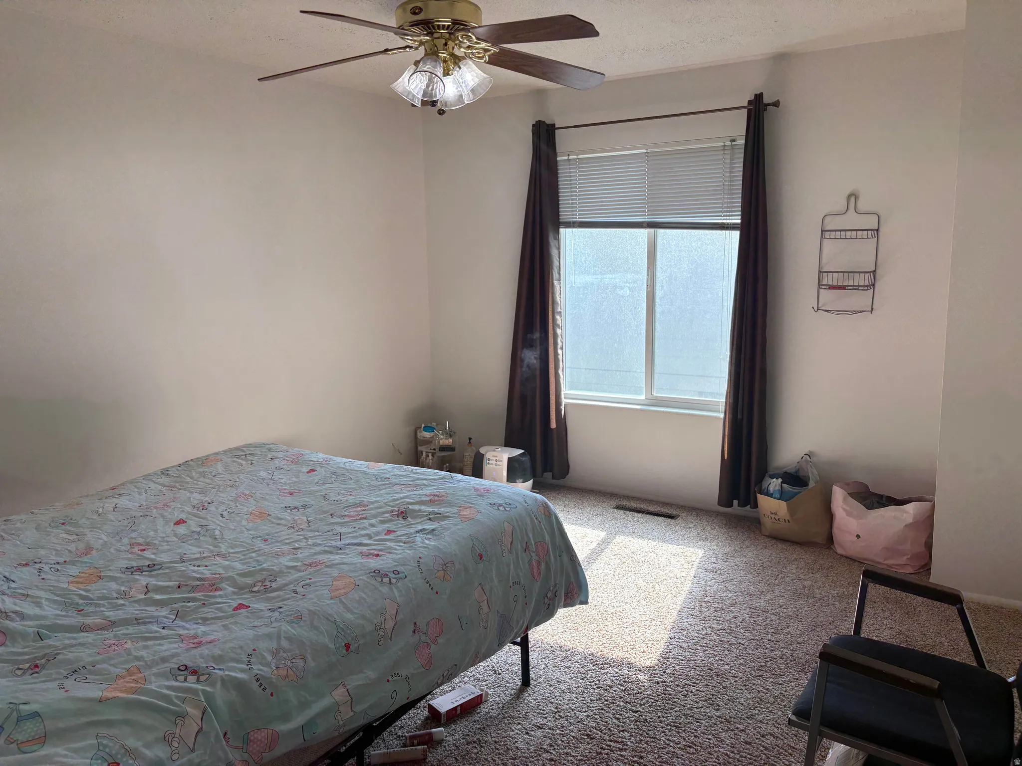 Bedroom featuring neutral wall paint, a window with horizontal blinds, and a ceiling fan with integrated lighting