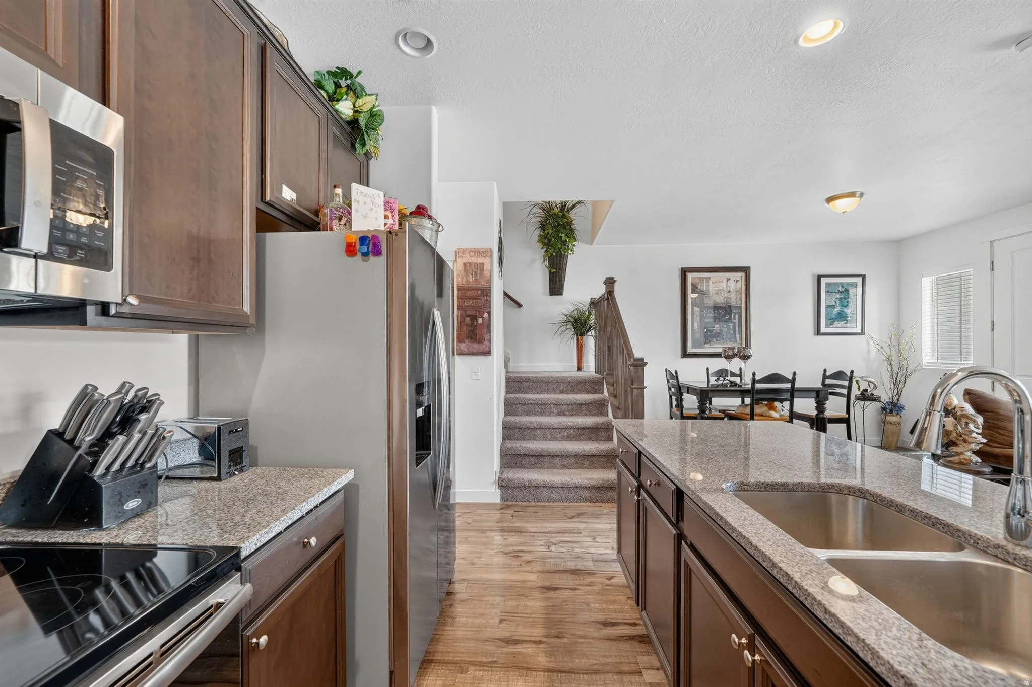 Kitchen featuring dark wood cabinetry, stainless steel appliances, and granite countertops