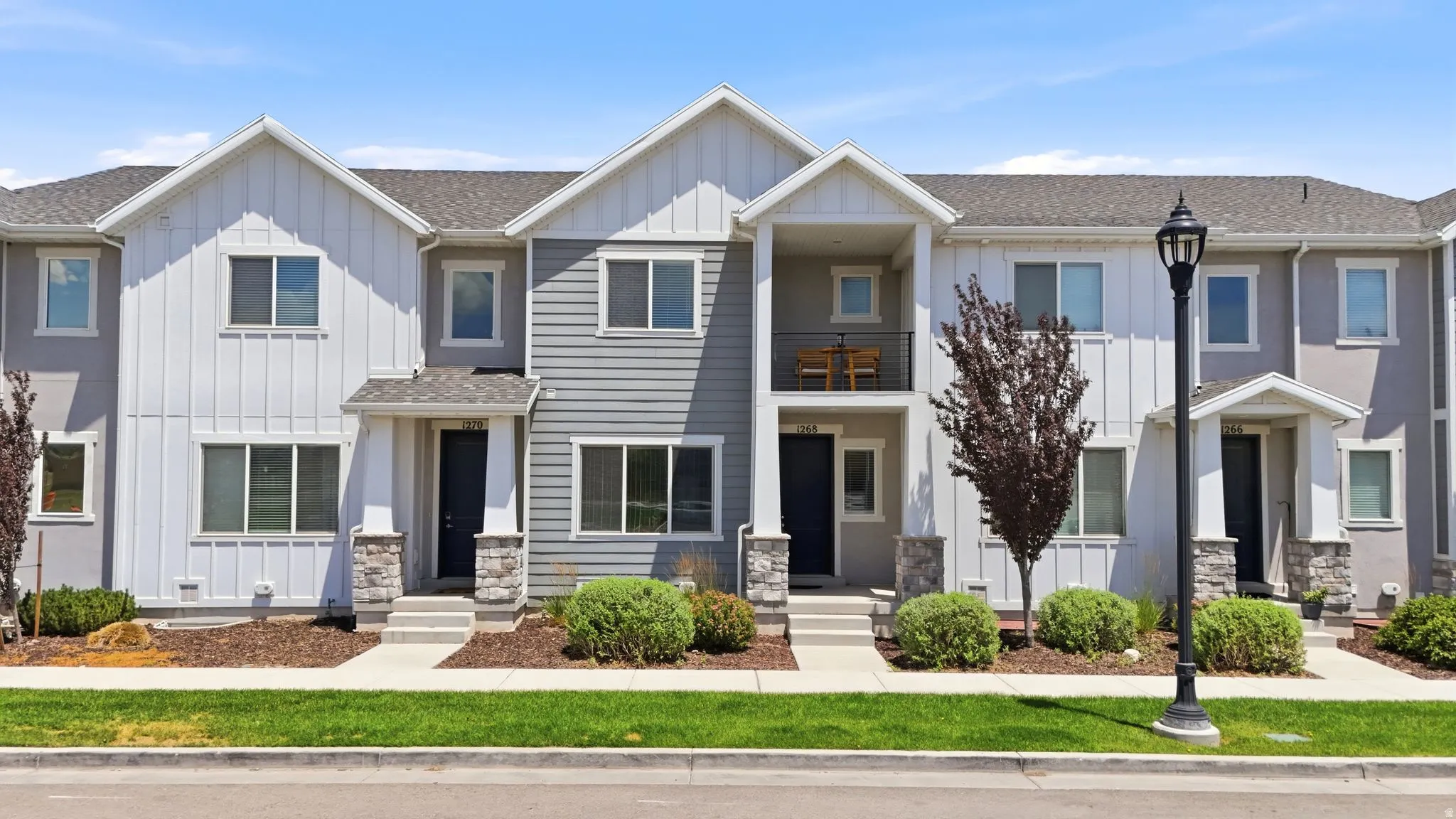 Contemporary townhome exterior featuring a combination of horizontal siding, vertical board and batten, and stucco finishes