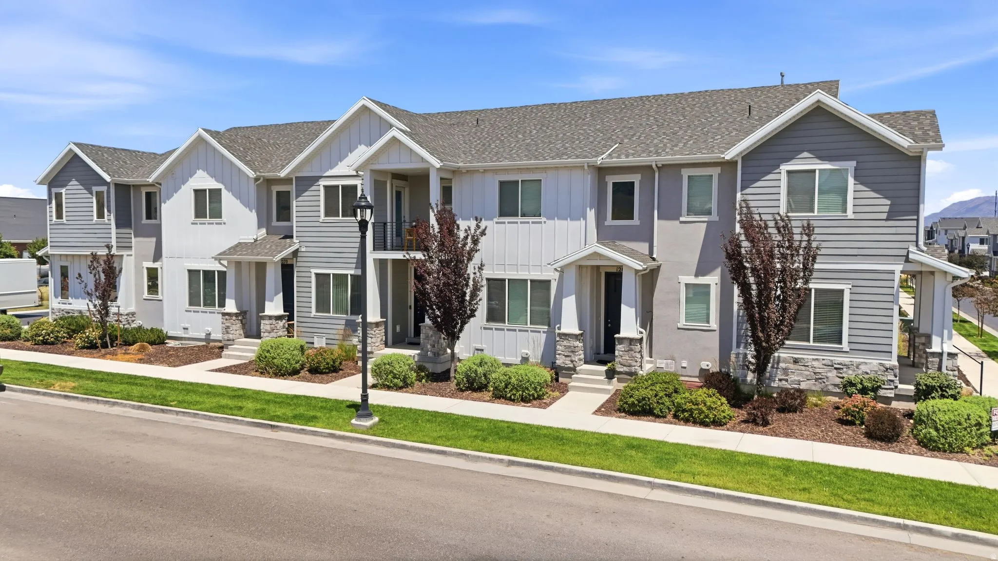 Contemporary townhome-style residences featuring a mix of siding and stucco exteriors