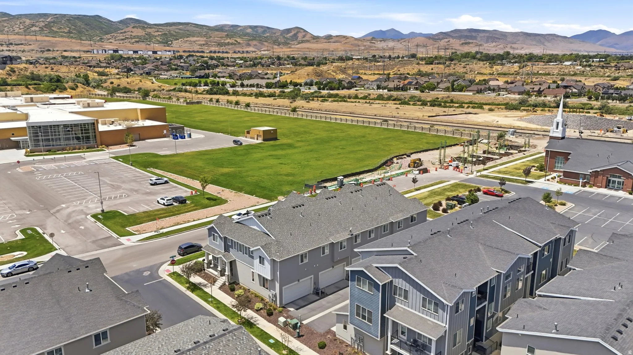 Modern residential complex featuring multi-level units with exterior balconies and attached garages