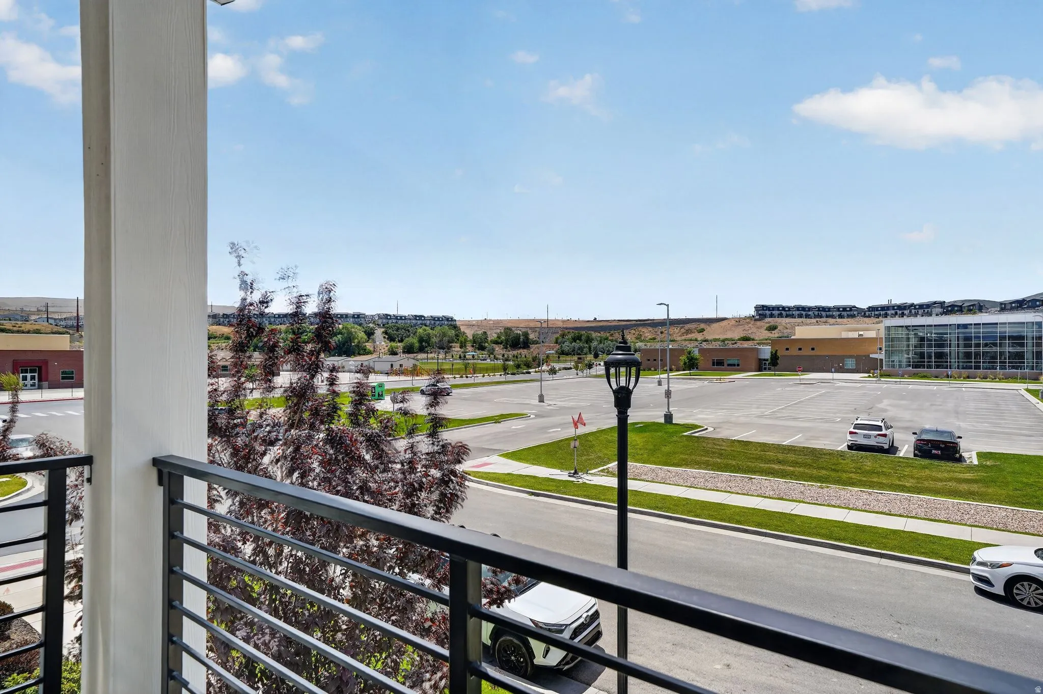 Balcony with horizontal metal railings and a white support column