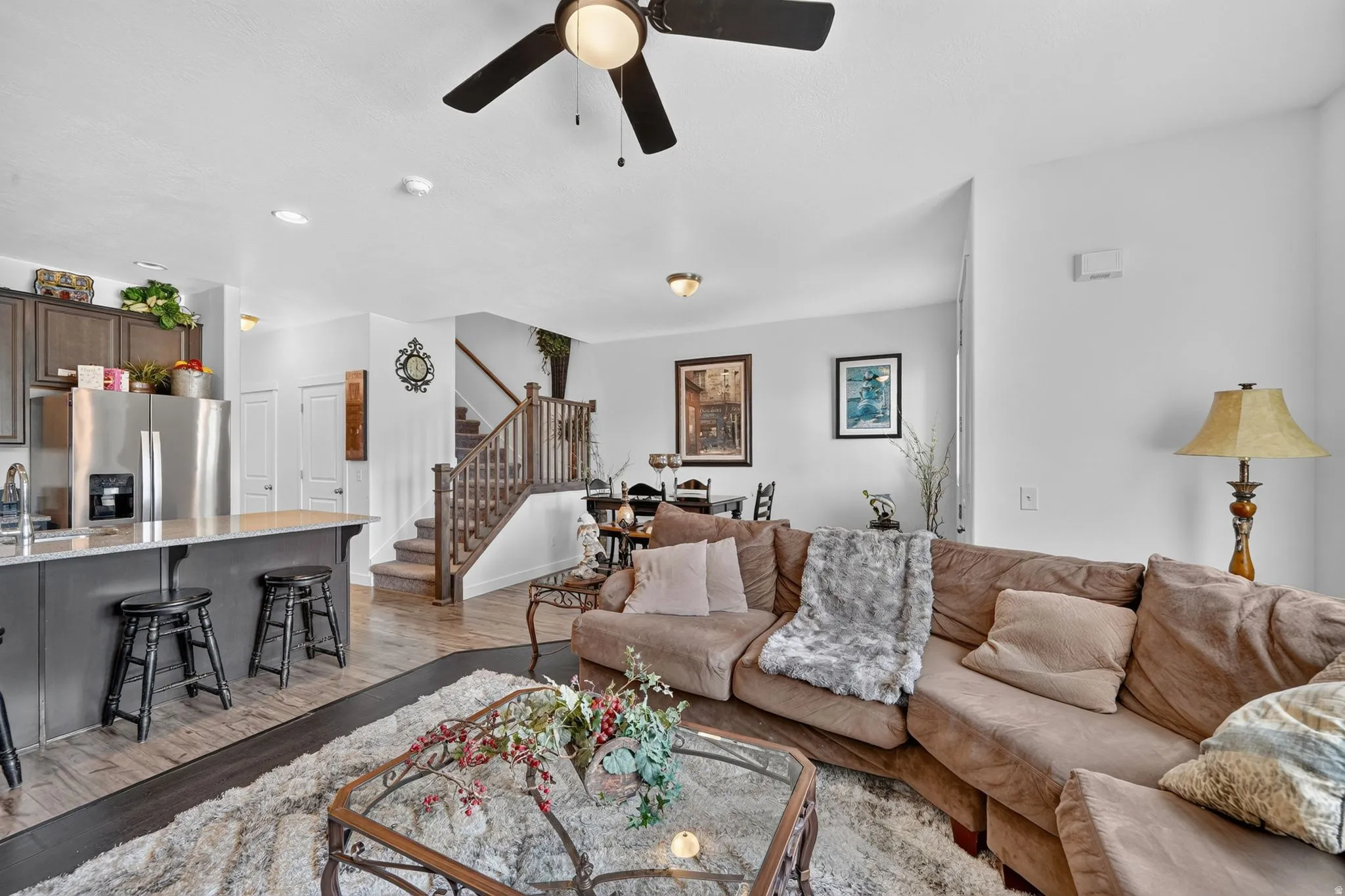 Open-concept living area with dark wood-finish flooring, a ceiling fan, and recessed lighting
