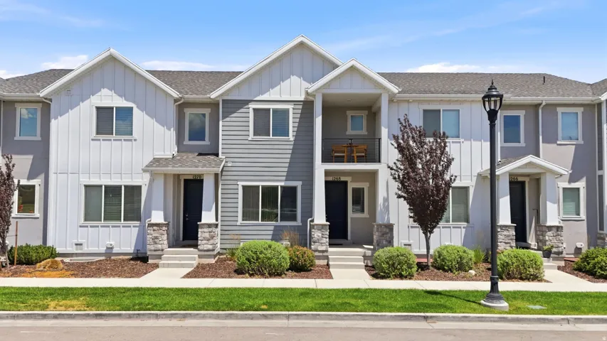 Contemporary townhome exterior featuring a combination of horizontal siding, vertical board and batten, and stucco finishes