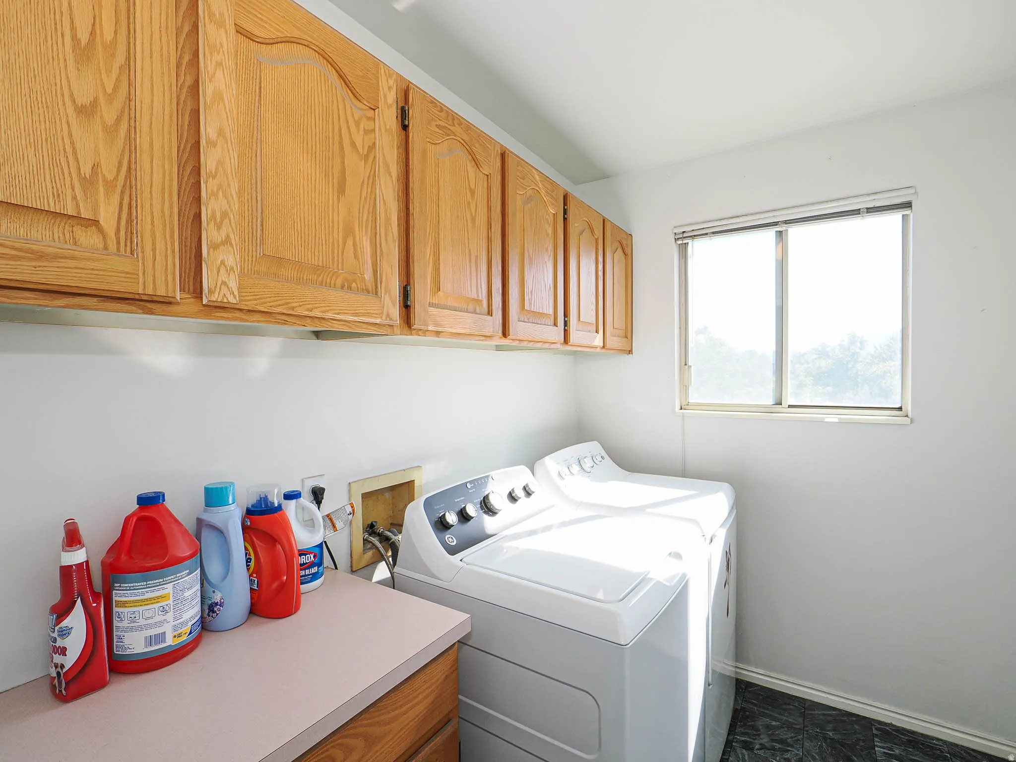 Dedicated laundry room featuring light wood-finish cabinetry