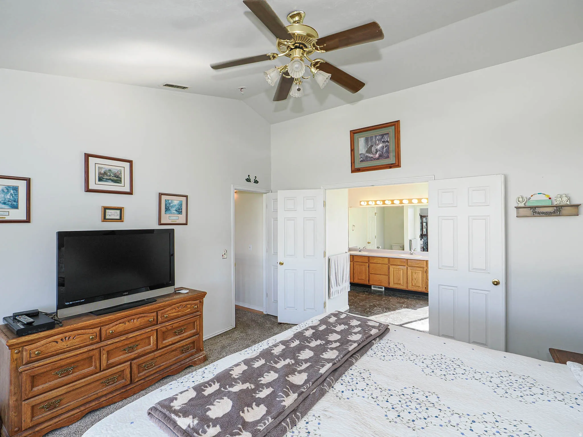 Vaulted ceiling with a ceiling fan and light fixture