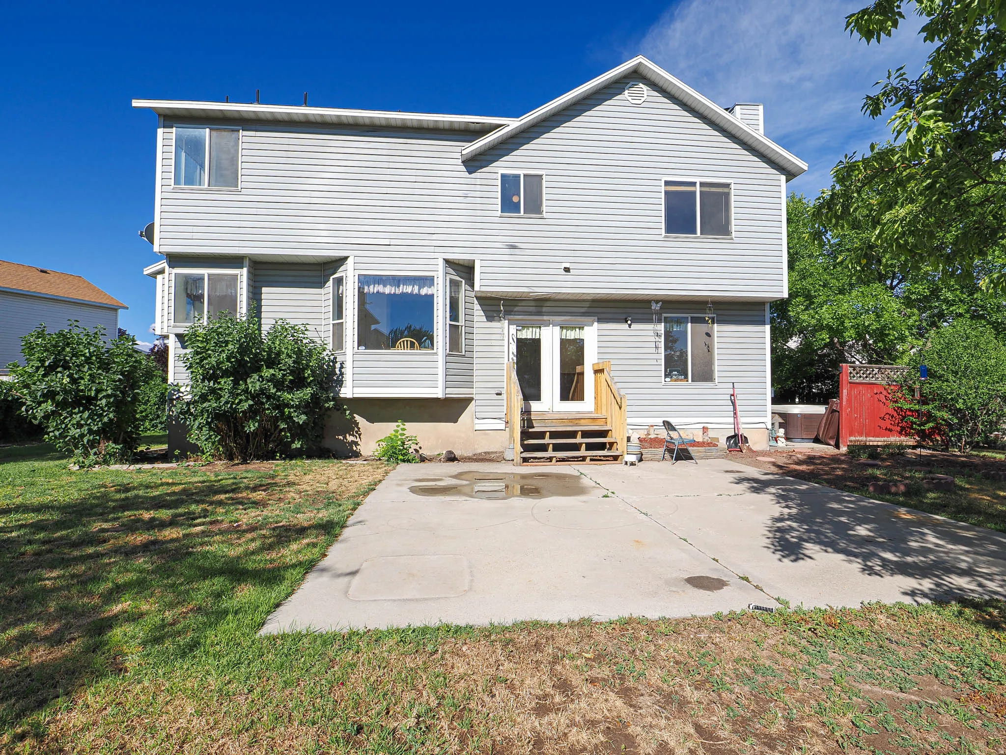 Rear exterior with light gray horizontal siding and a prominent bay window