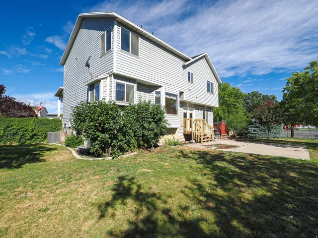 Two-story exterior featuring light gray siding, a gabled roofline, and multiple bay windows