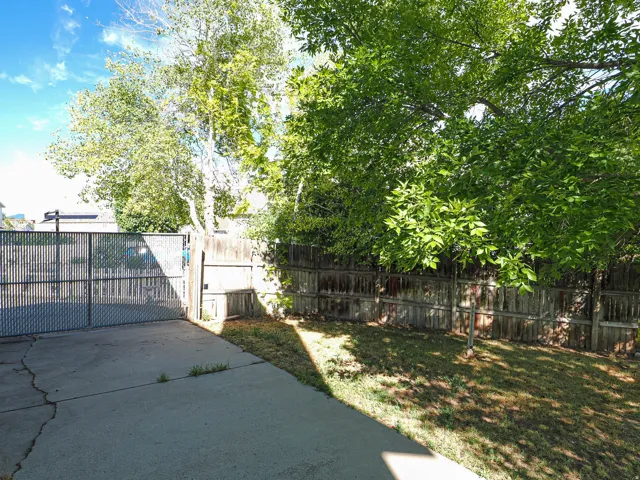 Paved concrete patio and drive area with a chain-link gate