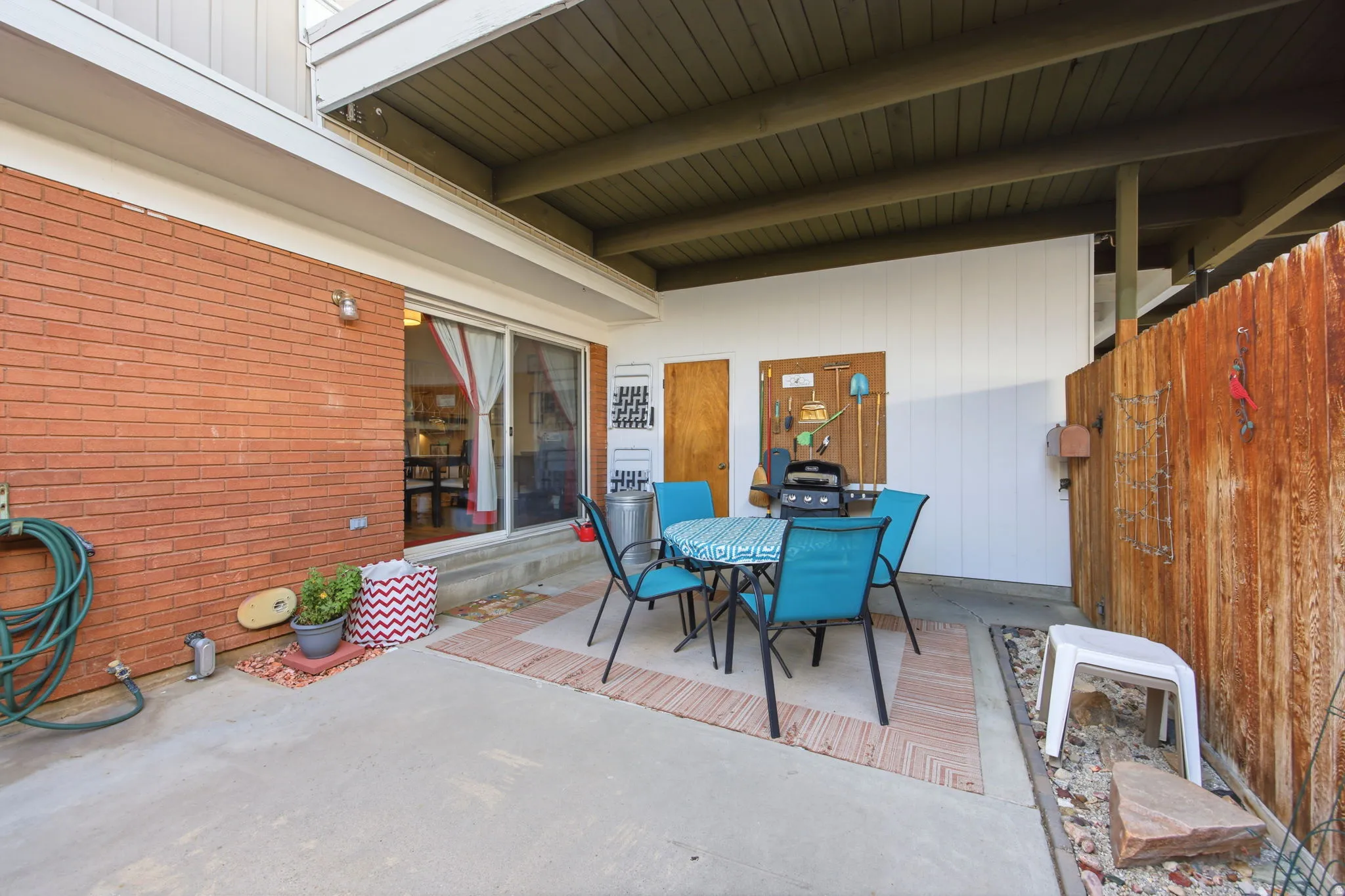 Private outdoor patio featuring a concrete slab and partial brick exterior