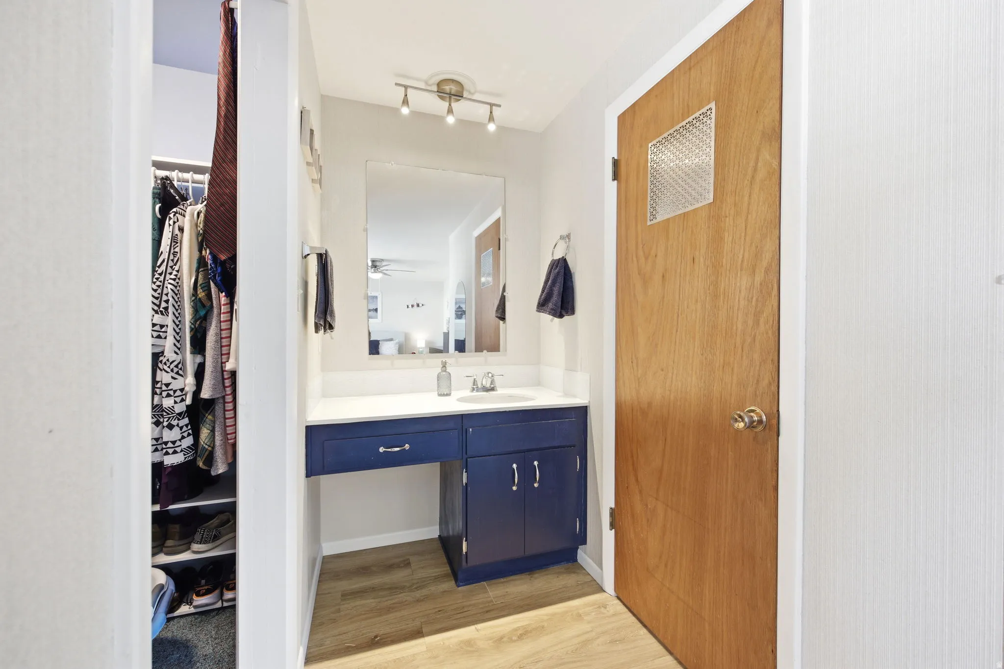 Vanity area featuring a deep blue cabinet, white countertop, and a wall-mounted mirror