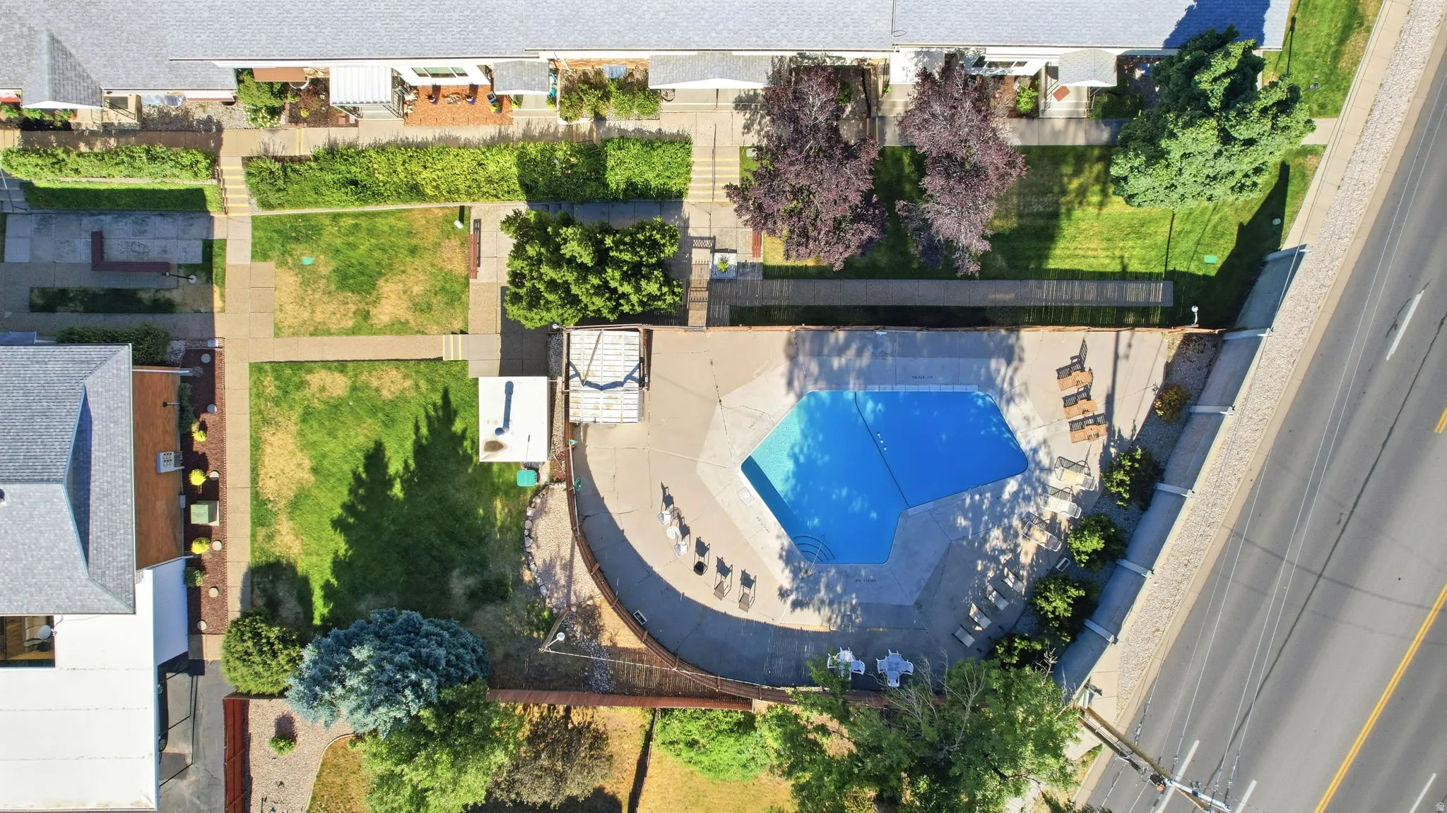 Outdoor swimming pool with surrounding hardscaping and perimeter fencing