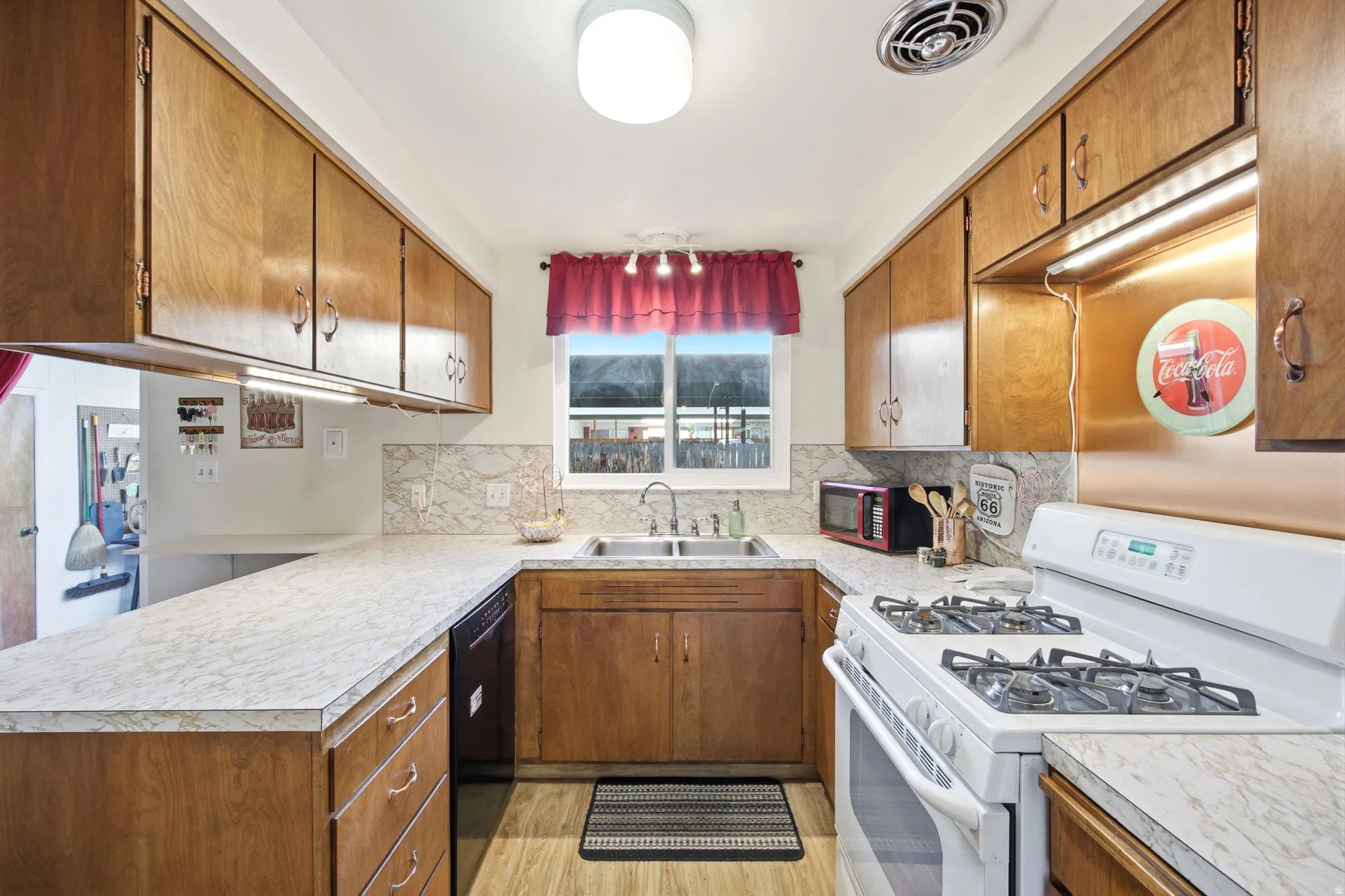 U-shaped kitchen featuring light wood cabinetry and light-toned countertops