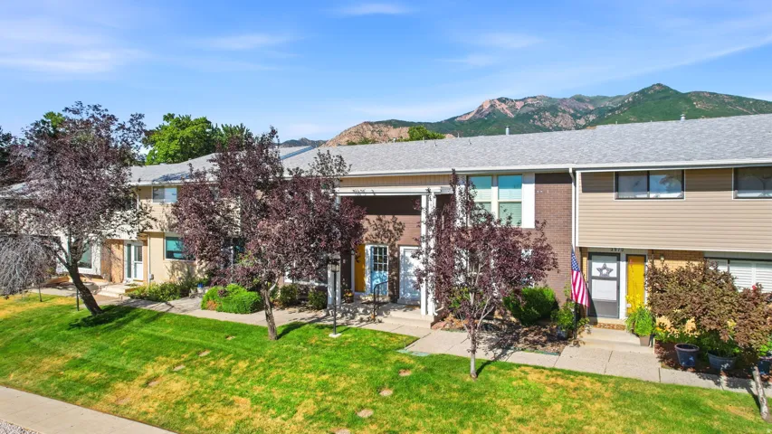Townhome exterior featuring tan siding and a dark brick facade