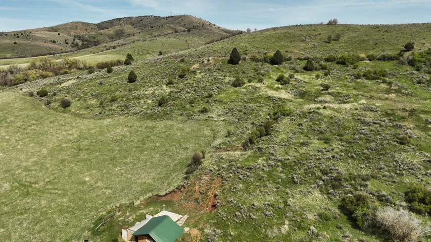 Expansive land featuring rolling hills with varied green vegetation