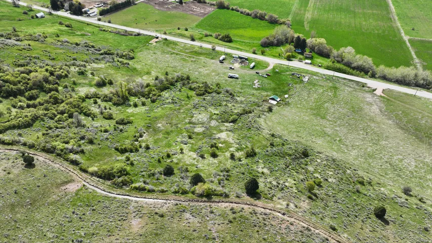 Expansive parcel featuring varied topography, a gravel path, and a partially wooded landscape