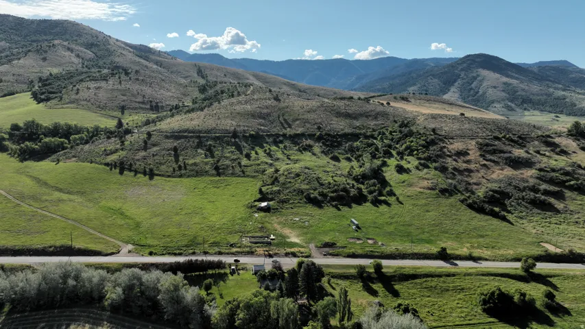 Expansive rural landscape featuring rolling green hills and distant mountains