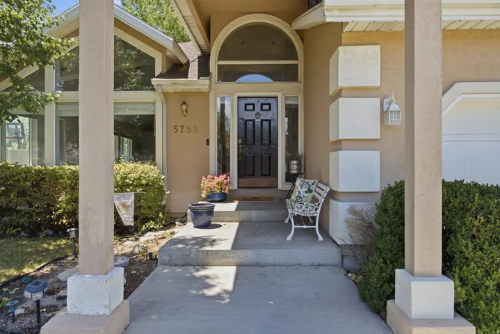 Stucco exterior with a prominent arched entry, decorative front door, and sidelight windows