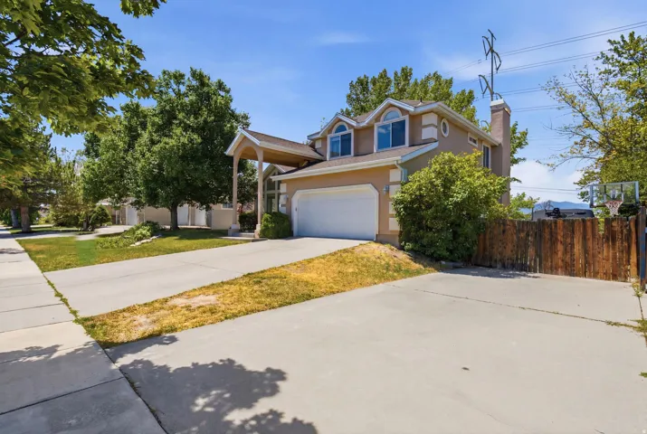 Two-story stucco exterior featuring an attached two-car garage, a covered entryway, and second-story dormer windows