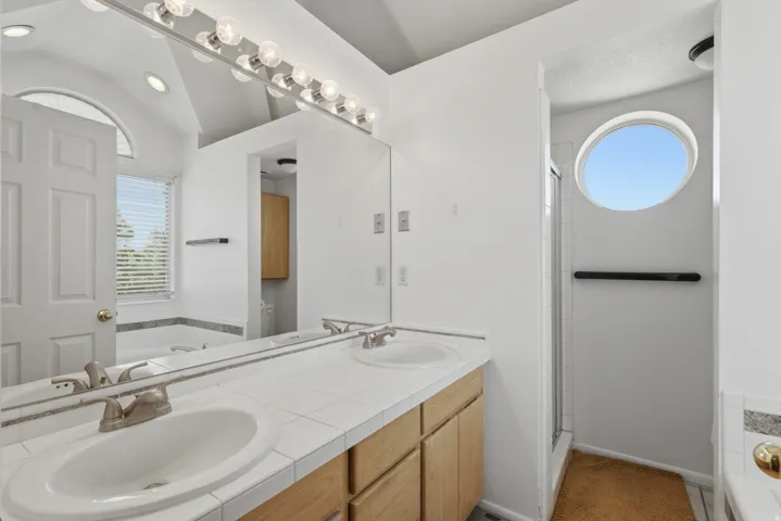 Dual vanity with wood-finish cabinetry and a tiled countertop