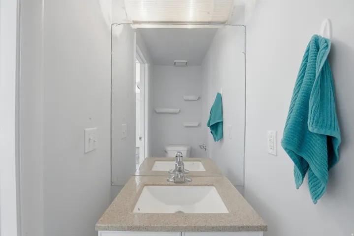 Bathroom vanity with an integrated sink, a speckled countertop, and a chrome faucet