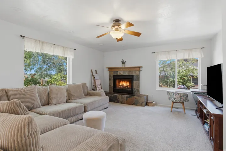 Living area featuring a stone-clad fireplace with a wood mantel