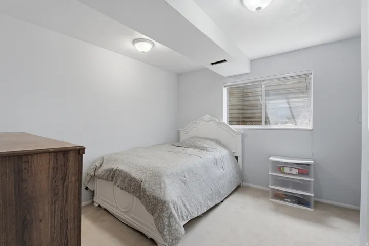 Bedroom featuring light-colored carpeting, a window with blinds, and recessed lighting