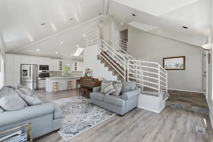Vaulted ceilings with recessed lighting and skylight define this open-concept living space