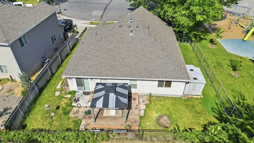 Backyard featuring a wood deck with a gazebo, a concrete patio area, and a storage shed