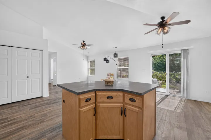 Central kitchen island featuring wood-finish cabinetry and a dark countertop
